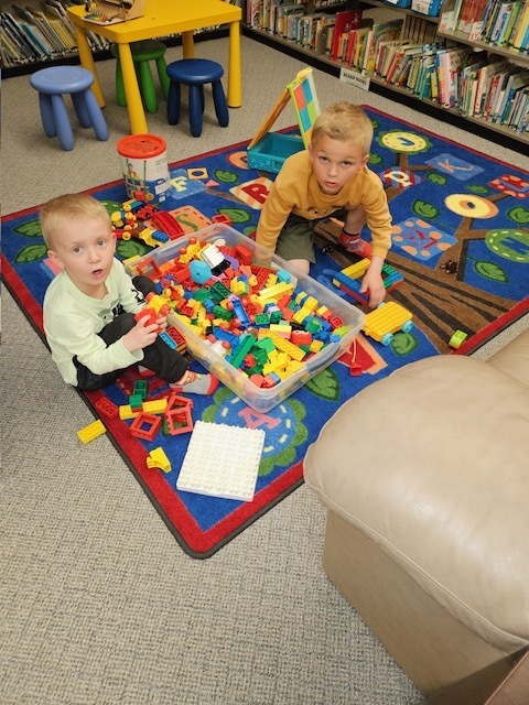 small boys on mat playing lego