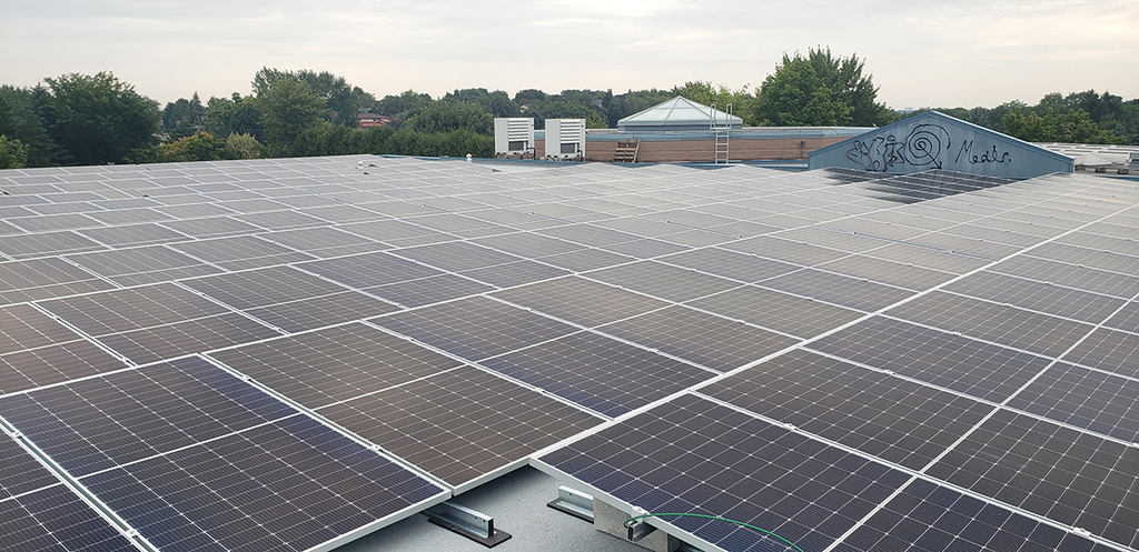 Solar arrays are pictured on the roof of a school.