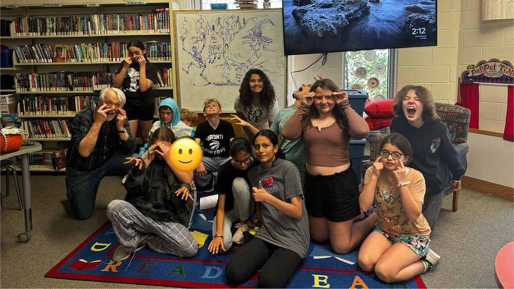 A group of students and adults in a school library.